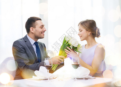 餐厅,夫妇假日微笑的男人给女朋友妻子花餐厅图片