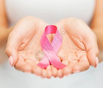 保护乳房妇女手捧粉红色乳腺癌意识丝带背景
