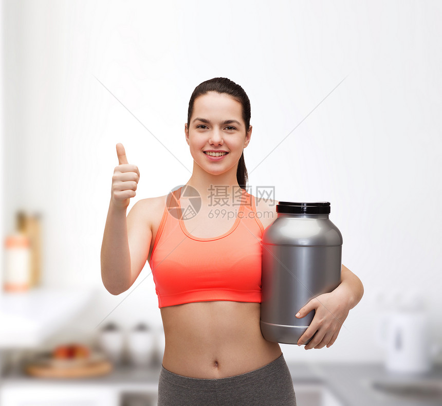微笑的女人抱着蛋白粉罐竖着大拇指图片