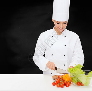烹饪食物微笑的女厨师切蔬菜图片