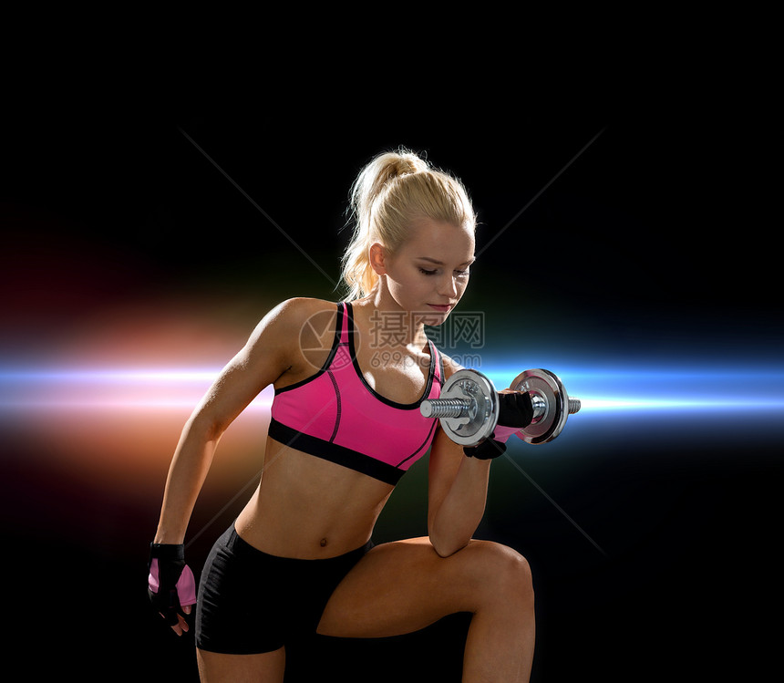 健身,保健节食的轻的运动妇女与沉重的钢哑铃图片