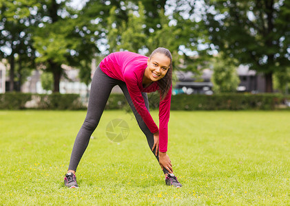 健身,运动,训练,公园生活方式的微笑的女人伸展腿户外图片
