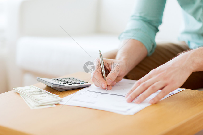 储蓄金融经济家庭用计算器家里数钱笔记的人的特写图片