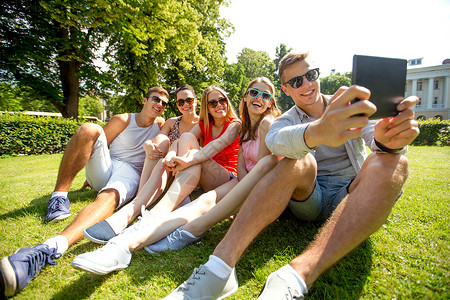 友谊,休闲,夏天,技术人的群微笑的朋友与平板电脑电脑坐公园里自拍图片