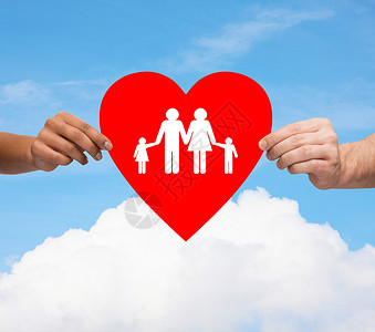 健康,爱,收养关系的特写多种族夫妇的手大红心与家人孩子蓝天白云背景背景图片