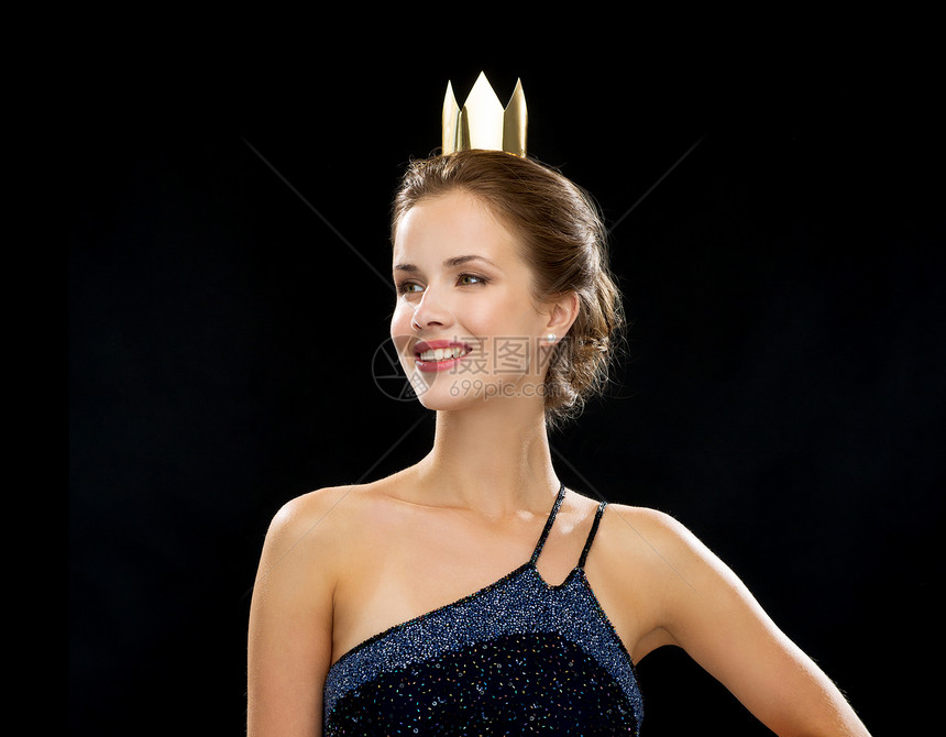 人,假日,皇室魅力微笑的女人穿着晚礼服,戴着黑色背景的金色皇冠图片