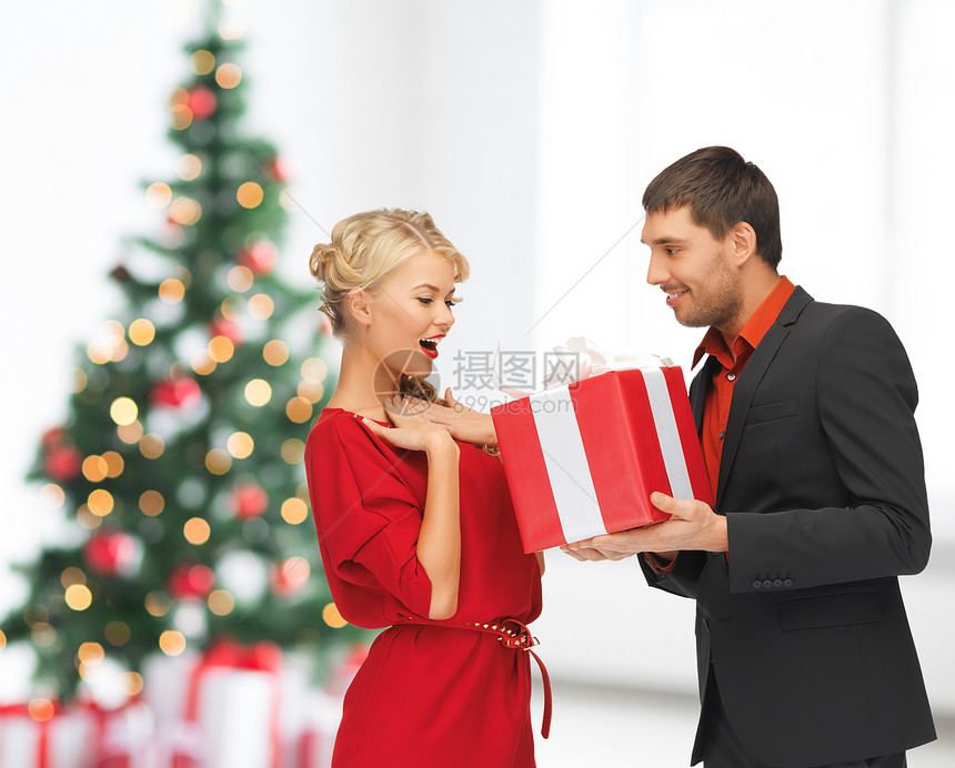 冬天,假期,诞节,庆祝人们的微笑的男人女人与礼物客厅与诞树背景图片