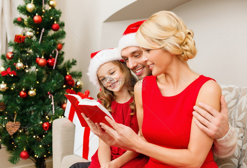 家庭,诞节,幸福人的微笑的家庭诞老人助手帽子与许多礼品盒阅读书籍图片