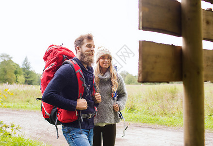 冒险,旅行,旅游,徒步旅行人们的微笑的夫妇背包站户外路标图片
