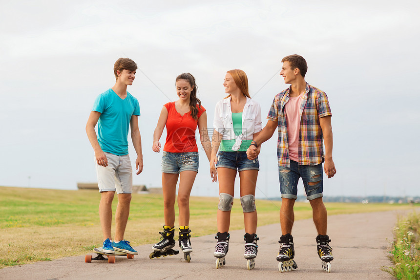 假期,爱友谊的群微笑的青少带着溜冰鞋滑板户外骑马图片