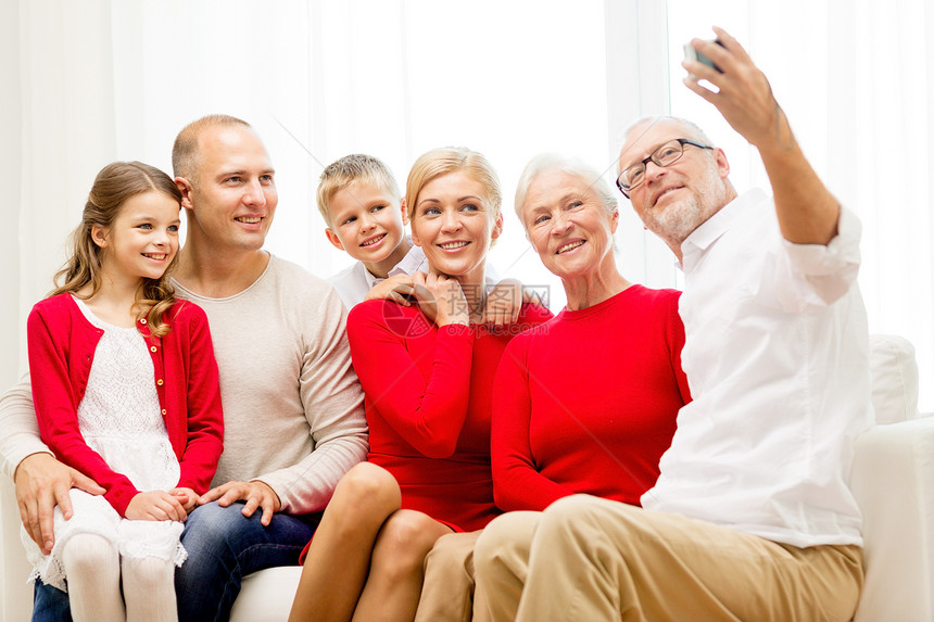 家庭,假期,代,诞节人们的微笑的家庭与相机,自拍坐沙发家里图片