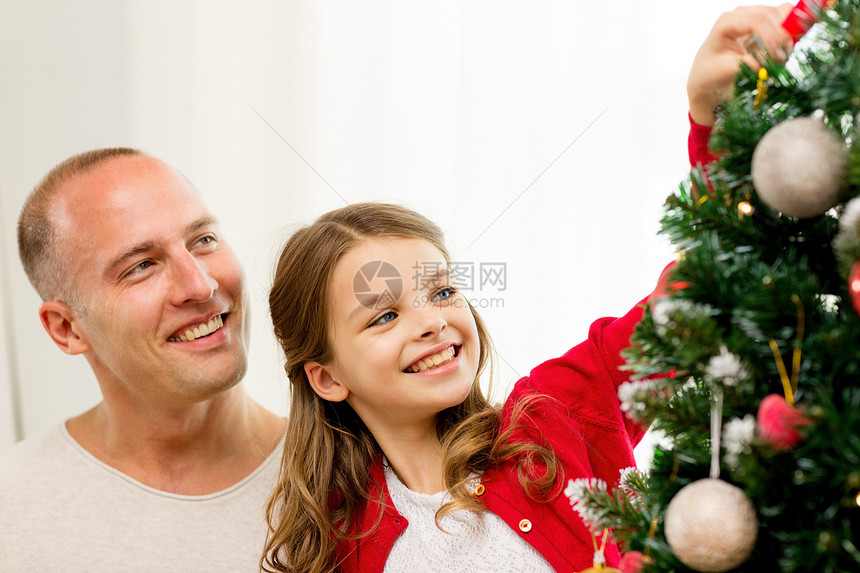 家庭,假期,世代人的微笑的女孩与父亲家里装饰诞树图片