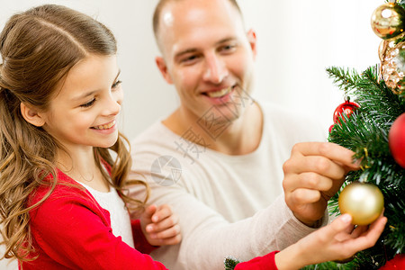 家庭,假期,世代人的微笑的女孩与父亲家里装饰诞树图片