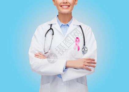 保健医学近距离微笑的女医生与听诊器粉红色的癌症意识丝带蓝色背景图片