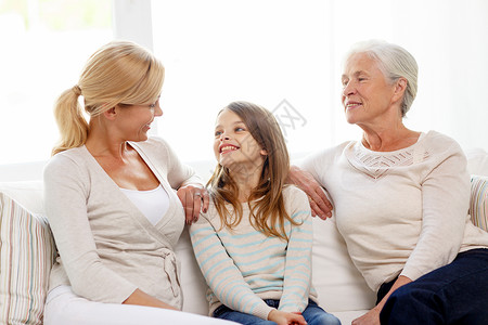 家庭幸福世代人的微笑的母亲女儿祖母坐家里的沙发上图片