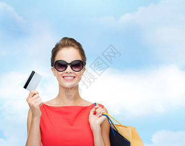 购物,销售,诞节假日微笑优雅的女人穿着红色连衣裙,带购物袋塑料卡袋子高清图片素材