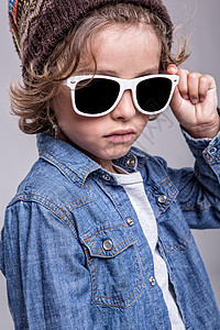 时尚小男孩戴着时髦的白色太阳镜图片