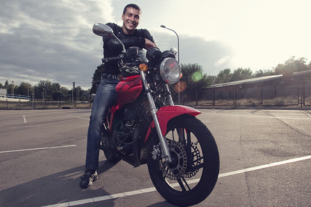 男人骑摩托轻的摩托车手坐运动摩托车上背景