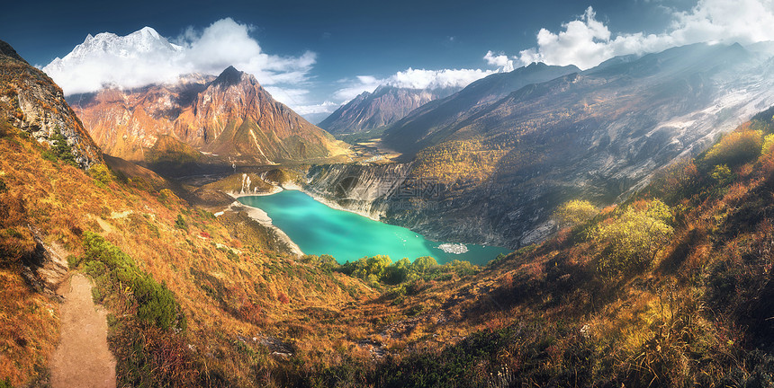 风景优美的喜马拉雅山,惊人的山湖与绿松石水,山丘,黄草,树木蓝天与云日落尼泊尔山谷全景景观图片