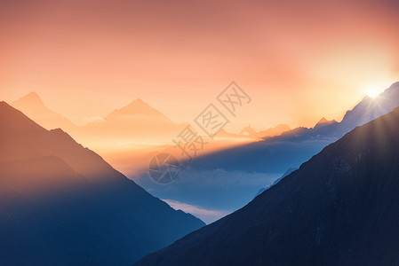 尼泊尔五颜六色的日出时,群山低云的轮廓的雄伟景象风景雪山的山峰,美丽的天空阳光岩石阳光自然背景背景图片