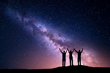 五颜六色的银河景观夜空中个幸福家庭的轮廓,山上举手臂美丽的宇宙太空背景图片