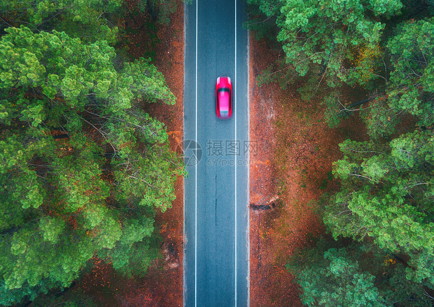 日落时,夏季森林里用模糊的汽车俯瞰道路令人惊叹的景观与乡村道路,树木与绿叶晴天穿过公园的高速公路飞行无人机的顶部图片