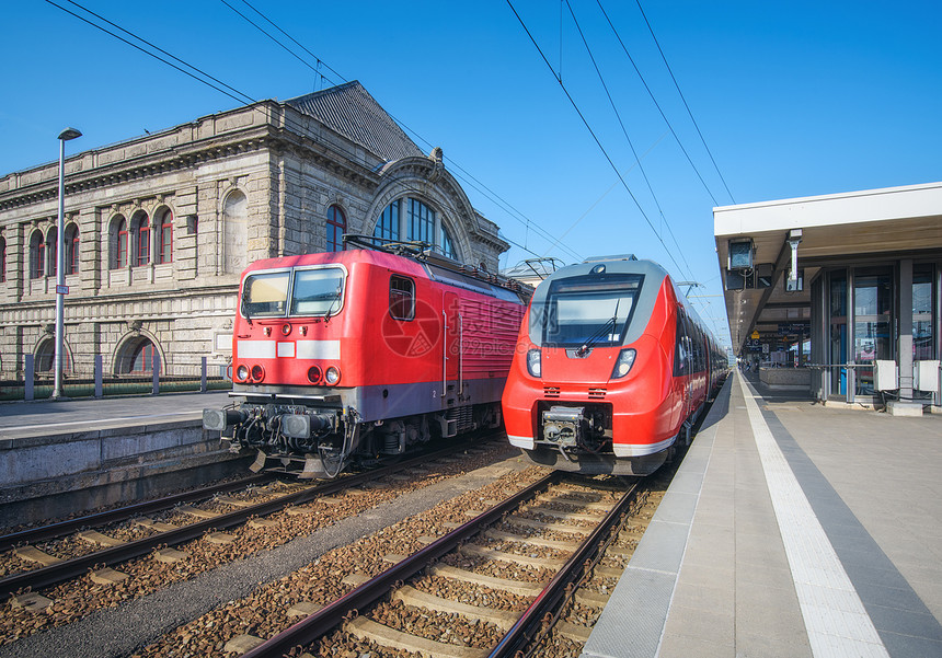 日落时火车站上的高速列车旧列车纽伦堡,德国铁路站台上的现代城际列车工业铁路上的通勤火车客运火车站上的高图片