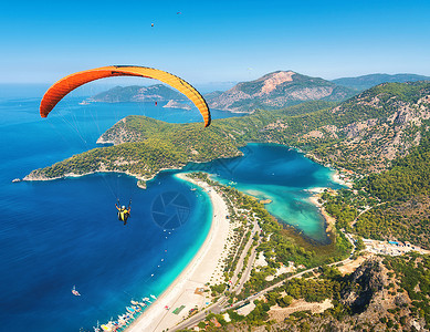 顶部比利茨基滑翔天空中滑翔伞阳光明媚的日子里,与蓝色的水山脉飞越大海鸟瞰滑翔伞蓝色泻湖奥卢德尼兹,土耳其极限运动背景