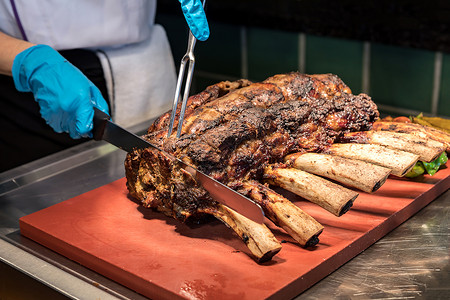 厨师雕刻烤瓦古牛肉的上等肋骨图片