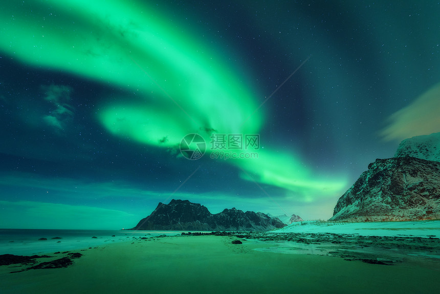 挪威洛福滕岛的北极光绿色北极光极地灯光的星空冬季景观明亮的极光海洋沙滩雪山晚上的乌塔克利夫海滩图片