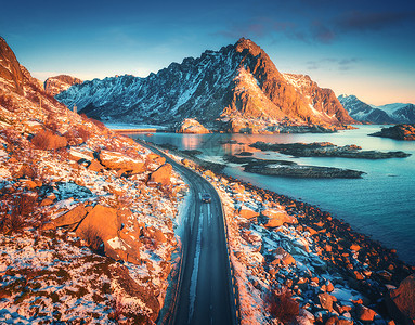 鸟瞰美丽的山路附近的海洋,山脉,紫色的天空日落洛福滕岛,挪威冬天顶部的道路,汽车,高雪岩与石头,海岸线,蓝色的水丰富多彩的高清图片素材