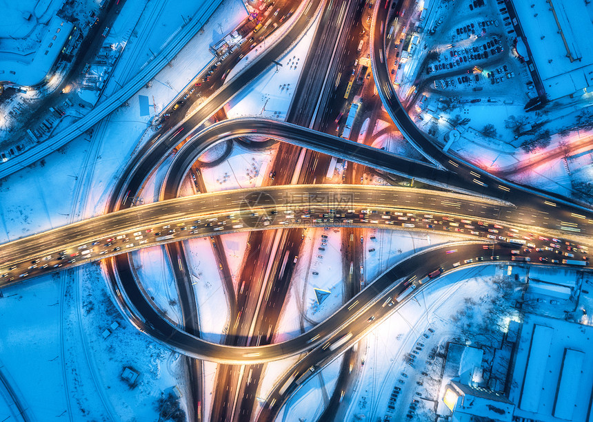 冬季夜间现代城市道路的鸟瞰图城市照明的高速公路交通顶部视图高架道路立交桥上的汽车繁忙的十字路口黄昏时的高速图片