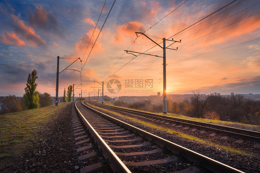 铁路日落时迎着美丽的天空工业景观与火车站,五颜六色的蓝天与红云,树木绿草,阳光铁路枢纽重工业图片