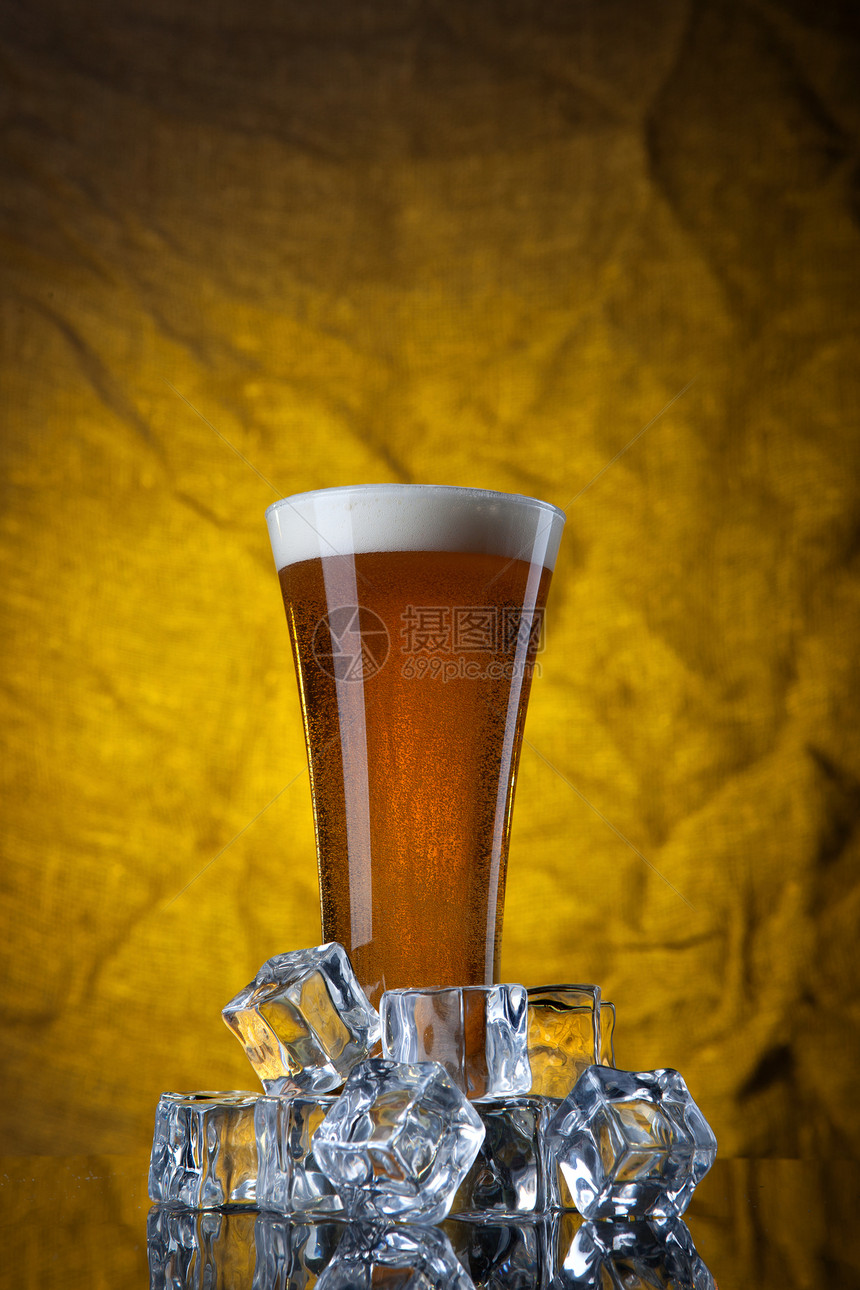 啤酒璃与冰块黄色背景图片