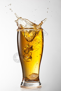 冰掉进啤酒璃,溅白色背景上图片