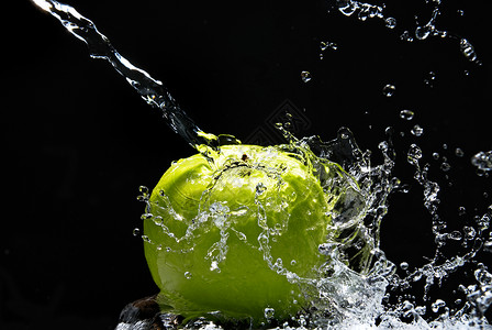 绿色苹果,水溅黑色背景上图片