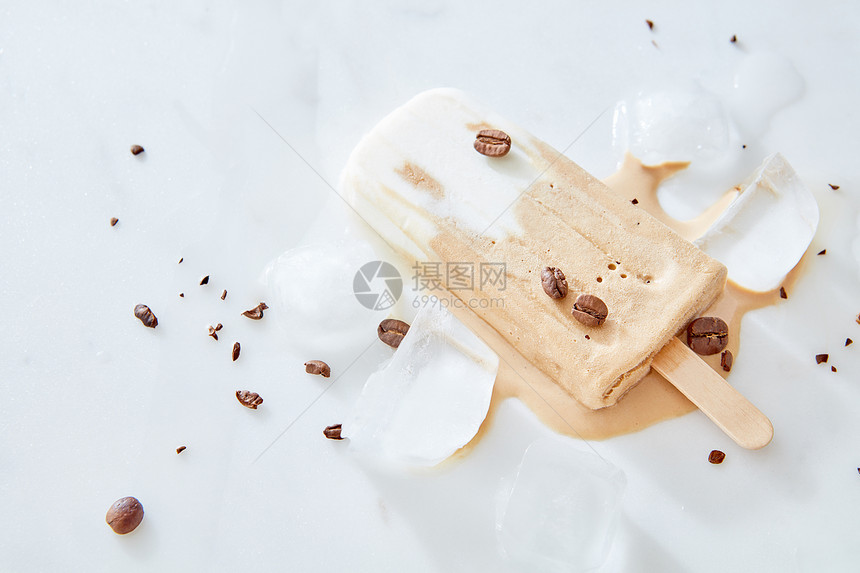 提拉米苏冰棒冰淇淋与咖啡豆木棒上大理石背景,顶部视图冰淇淋与牛奶巧克力咖啡豆木棒上的石头冰桌上,顶部视图图片