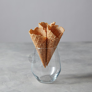 空华夫饼锥,用于灰色背景的璃中冷山梨甜蜜的夏天三个空的圆锥体个璃花瓶里站个灰色的石桌上图片