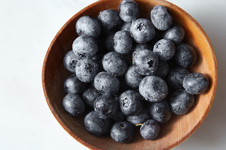 天然新鲜的国产水果特写美味浆果甜点厨房餐桌的配料成熟的甜蓝莓水滴中,灰色背景的木盘里的风景背景图片