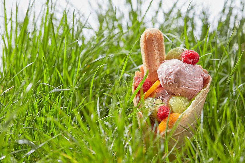 美味的冰淇淋与浆果,水果饼干华夫饼锥背景下的绿色草冰淇淋水果华夫饼锥里图片