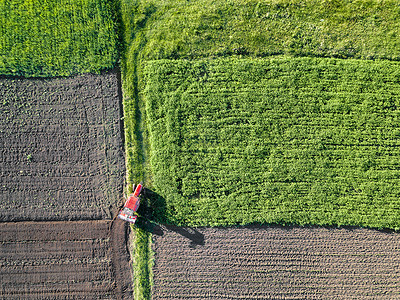 农田的鸟瞰图,耕地拖拉机田里工作无人机的照片农业春天农田的鸟瞰图图片