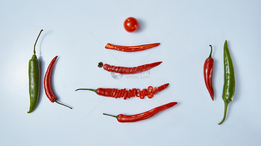 创意布局由辣椒红青椒番茄制成,平躺食物灰色背景上分离的蔬菜灰色背景上辣椒番茄的布局图片