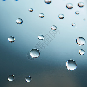 美丽的小水滴蓝色渐变背景的璃上蓝色渐变背景上璃上的小水滴图片