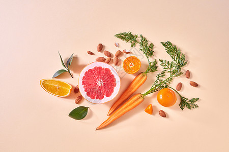 天然机柑橘类水果蔬菜黄纸背景下制作自制排冰沙的原料,平躺胡萝卜,橘子片柚子片,曼达林,杏仁,绿叶背景图片