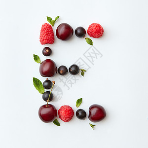 字母e英文字母以自然机浆果的形式出现成熟的新鲜树莓黑色醋栗樱桃绿色薄荷叶白色背景上分离顶部视图新鲜水果图案的字背景图片