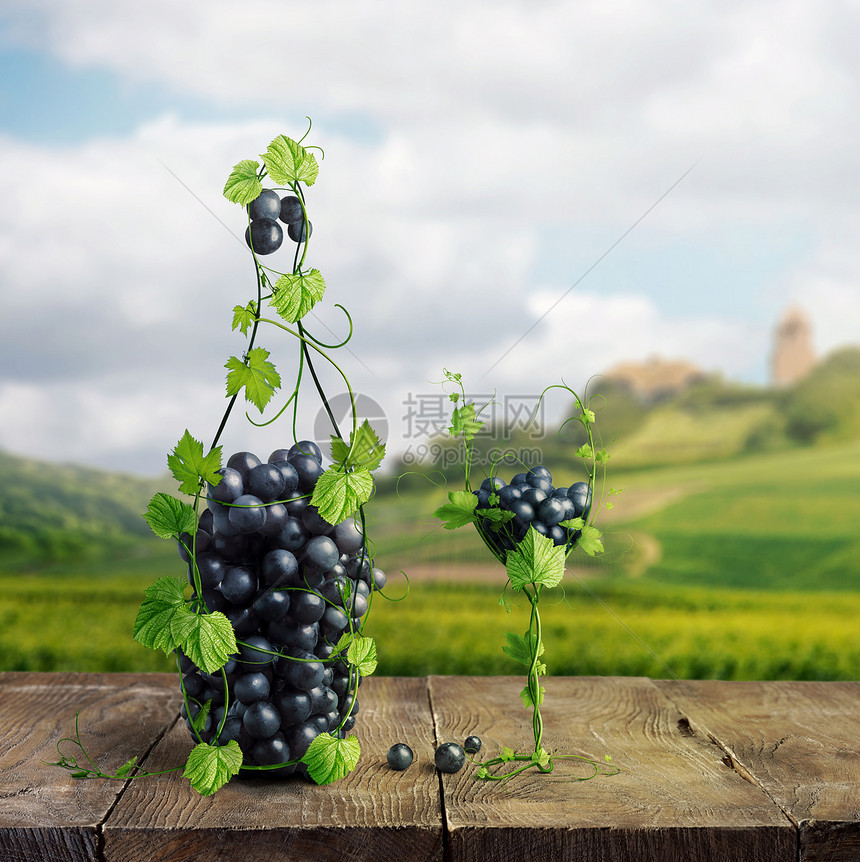 杯葡萄酒瓶葡萄酒,由葡萄叶串葡萄个木制的背景上,模糊的背景俯瞰绿色的山峰杯葡萄酒瓶葡萄酒,由葡萄叶串图片