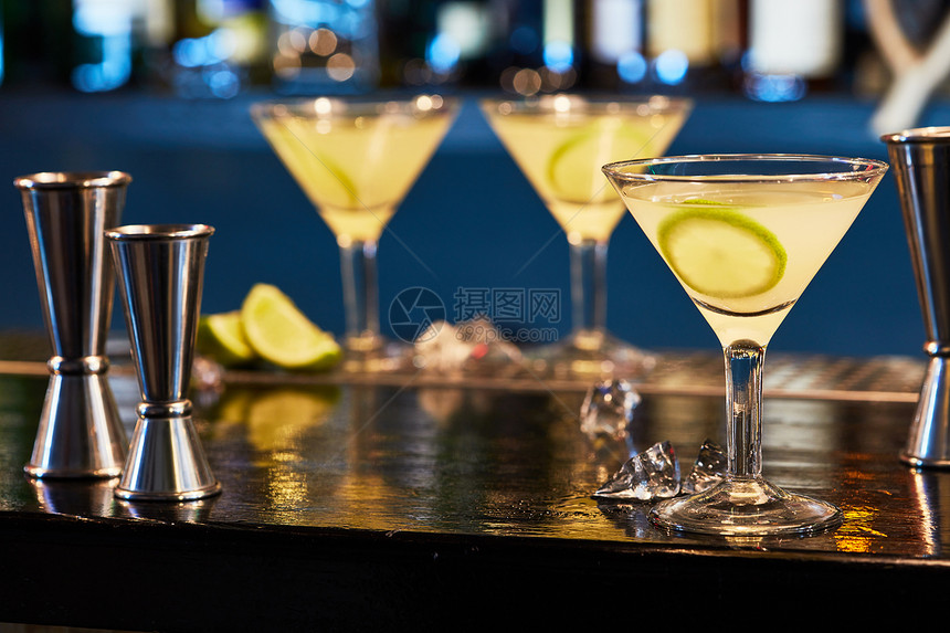 冰冷鸡尾酒马提尼杯与切片石灰酒吧桌子上酒吧里美味的鸡尾酒图片