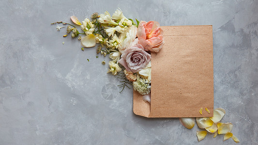 美丽的花信封上的石头灰色背景的风景爱情人节的图片