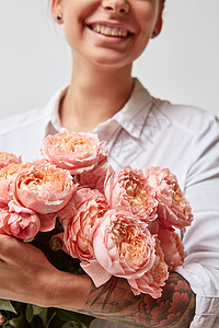 微笑的女人着大粉红色的玫瑰情人节,母亲节花的女孩图片