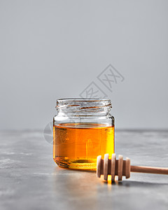 天然甜甜点机蜂蜜个璃锅与北斗七星个灰色的石桌,罗什哈沙纳犹太传统的纯天然甜善甜蜂蜜璃瓶里背景图片